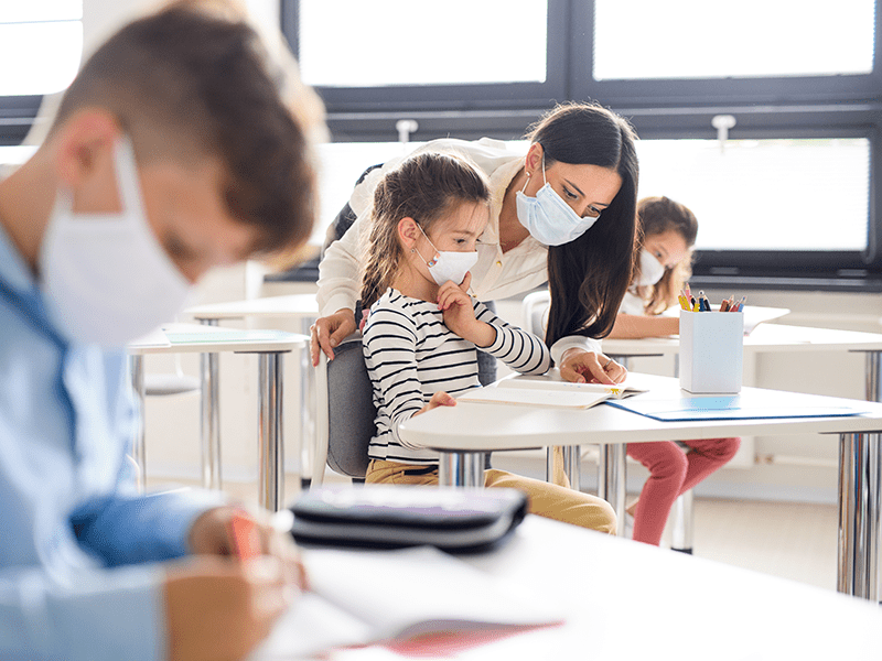 Teacher helping children in a classroom